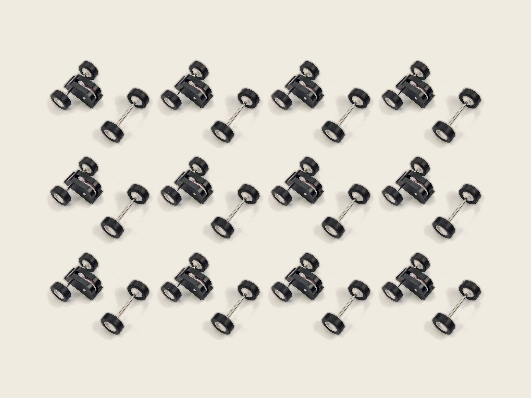 Twelve Scamp pull-back motors with their matching front wheel-and-axle sets